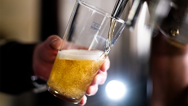 タップからクラフトビールを注ぐバーテンダー