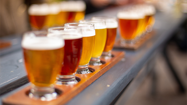 木のテーブルに並ぶ複数のビール